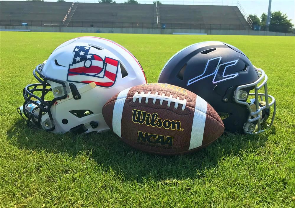  Bob Jones and James Clemens helmets facing each other on a football field 